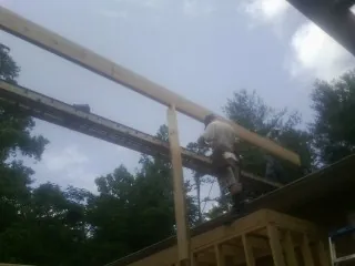 Carpenter setting a ridge beam over a new addition frame — Ice Dam Removal by Roofing Brothers in Island Park