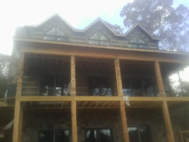 Dormers and porch framing on a large log home under construction — Roof Coating work by our crew in Island Park