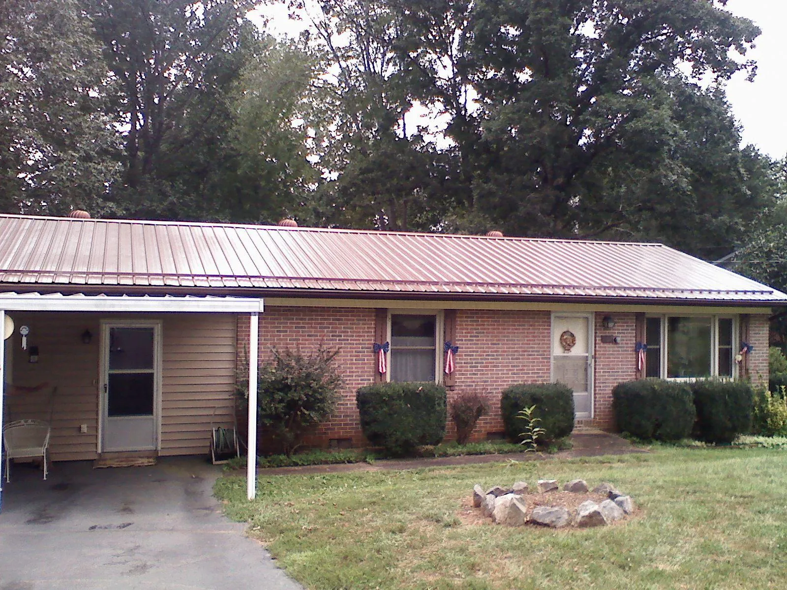 Bronze metal roof and carport on a brick ranch home — Roof Repair work by our crew in Island Park